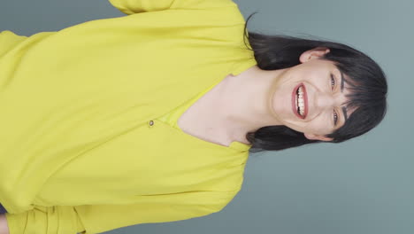 Vertical-video-of-The-woman-promoting-is-pointing-to-the-side-and-laughing.